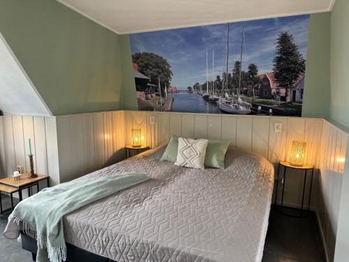 a bedroom with a bed with a painting on the wall at Hotelhuisjes Medemblik in Wieringerwerf