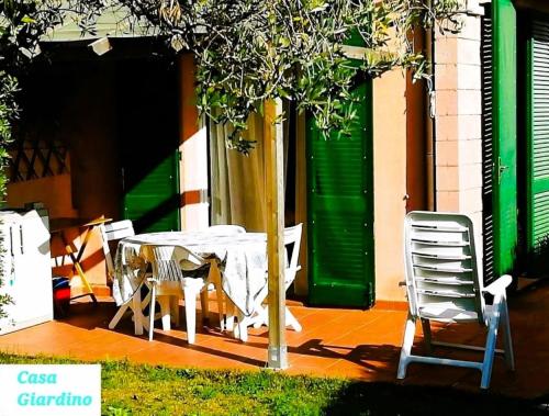 a table and chairs under a tree next to a building at Casa Giardino in Marina di Campo