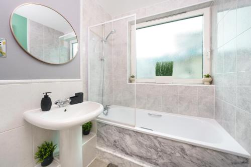 a white bathroom with a sink and a mirror at St George Thames Apartment in London