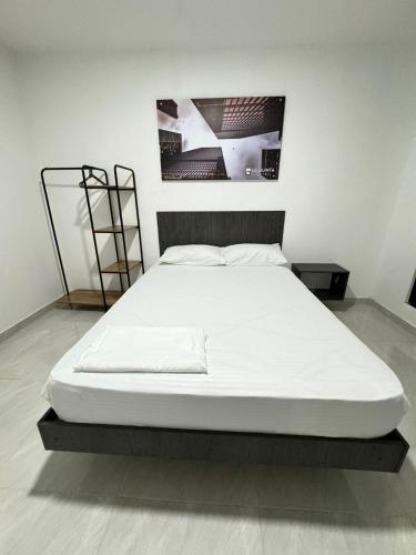 庫庫塔的住宿－HOTEL LE QUINT，白色客房内的一张大白色床