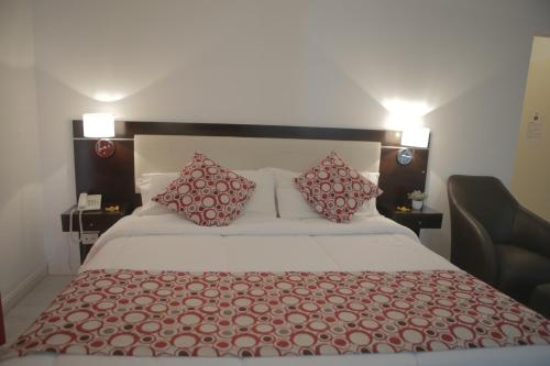 a bedroom with a large bed with red pillows at Pampa Plaza Hotel in Buenos Aires