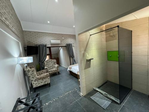 a bathroom with a shower and a bedroom with a bed at Echo Mountain Inn in Thabazimbi