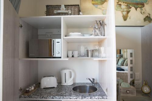 a kitchen with a sink and a microwave at 43 On Sandstone in Somerset West