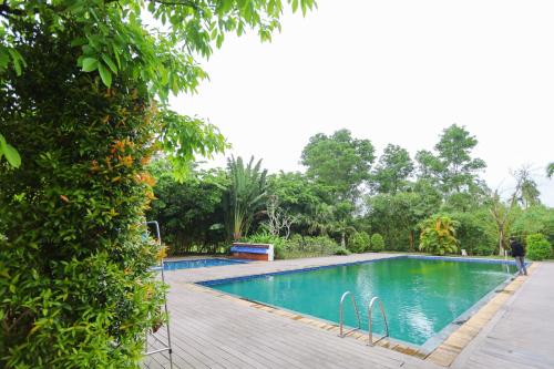 uma piscina num jardim com um deque de madeira em Kenpi Garden Homestay - NGUYÊN CĂN, đậu nhiều ô tô em Hue