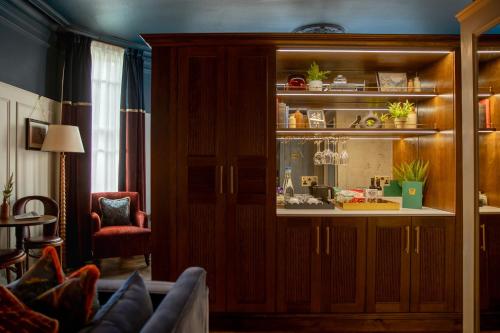 a living room with a large wooden cabinet at Worplesdon Place Hotel in Guildford