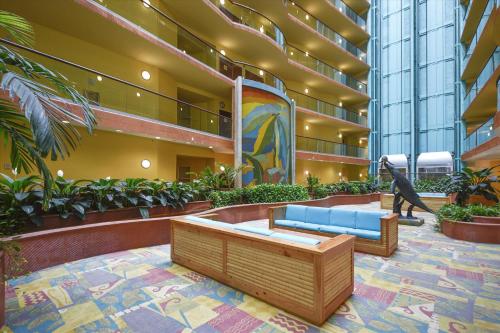 eine Lobby mit einer blauen Couch und einer Dinosaurierstatue in der Unterkunft Caribe Resort Unit C814 in Orange Beach