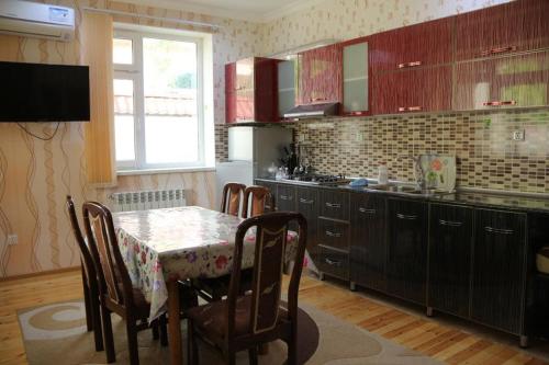 a kitchen with a table with chairs and a table and a tableablish at Qabala_Renting_houses near the mountain in Gabala