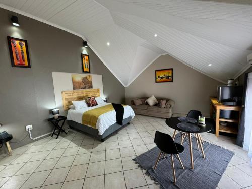 ein Schlafzimmer mit einem Bett und einem Sofa in der Unterkunft Echo Mountain Inn in Thabazimbi