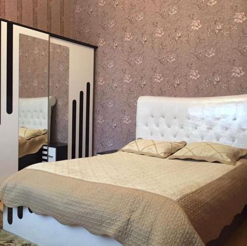 a bedroom with a large bed and two mirrors at Qabala_Renting_houses near the mountain in Gabala
