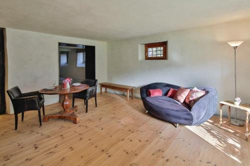 a living room with a blue couch and a table at Ferien im Baudenkmal Toggenburg in Krummenau