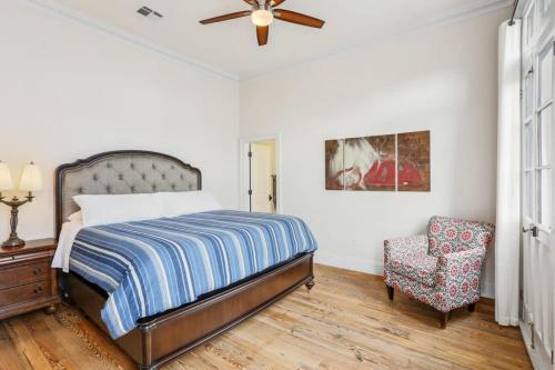 a bedroom with a bed and a chair and a ceiling fan at The Burgundy House #1 Steps to the French Quarter in New Orleans
