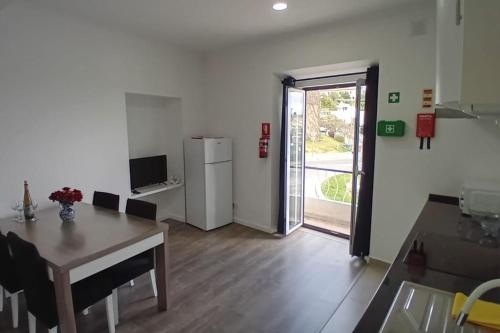 uma sala de estar com uma mesa e um frigorífico em Apartment in Semeador 1 em Portalegre