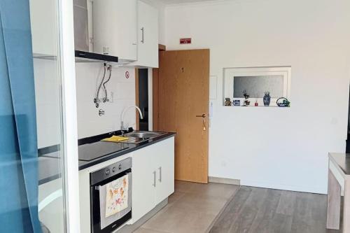 uma cozinha com um lavatório e um fogão forno superior em Apartment in Semeador 1 em Portalegre