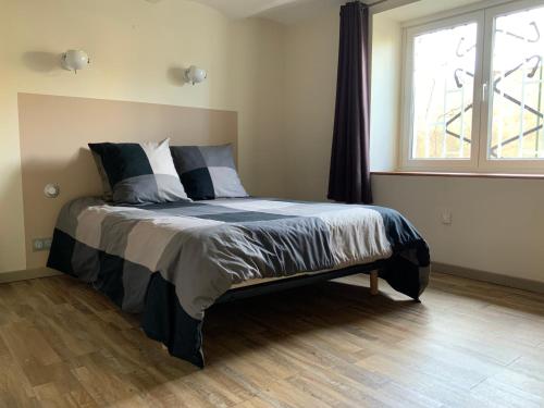 a bed in a bedroom with a large window at Au petit bonheur in LʼIsle-sur-la-Sorgue