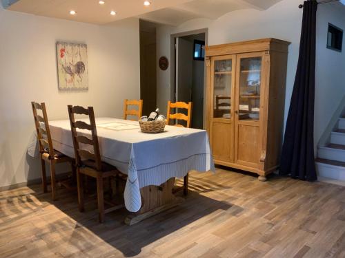 une salle à manger avec une table, des chaises et une armoire dans l'établissement Au petit bonheur, à LʼIsle-sur-la-Sorgue