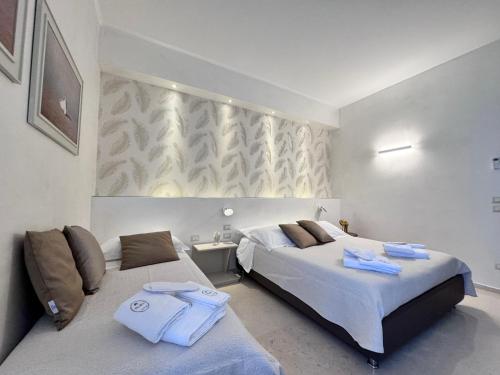 a bedroom with two beds with towels on them at Bebio Rooms in Trani