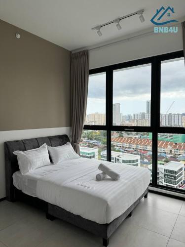 a bed in a room with a large window at Urban Suites @ George Town Penang by BNB4U in George Town