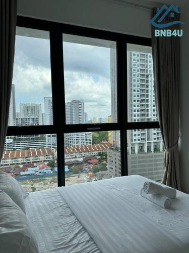 a bed with a view of a city from a window at Urban Suites @ George Town Penang by BNB4U in George Town