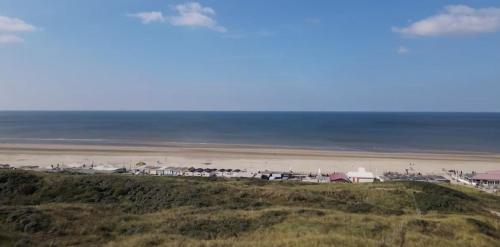 a view of a beach with houses and the ocean at Sonnevanck Wijk aan Zee in Wijk aan Zee