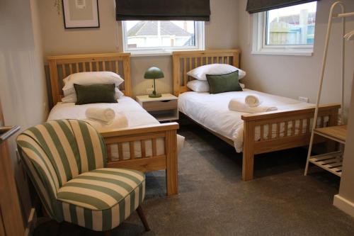 um quarto com 2 camas, uma cadeira e uma janela em 4 Bedroom Getaway New Forest em New Milton
