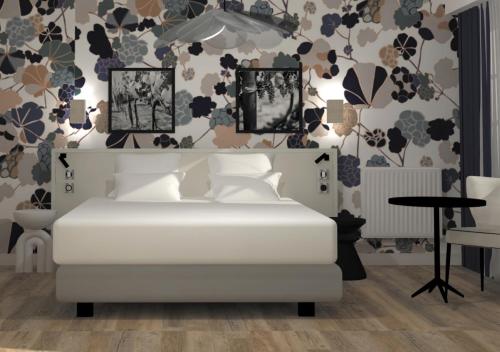 シノンにあるGabriel Hotel Chinonの白いベッドと花の壁紙が備わるベッドルーム1室が備わります。