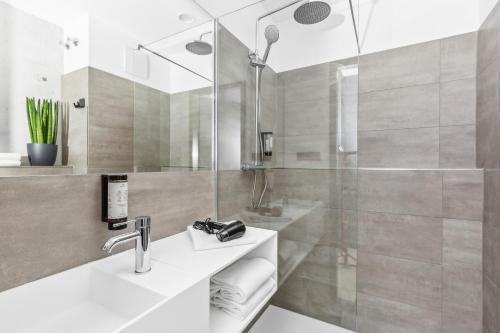 y baño con lavabo y ducha. en Nena Apartments München City East - NEW OPENING 2024 en Múnich