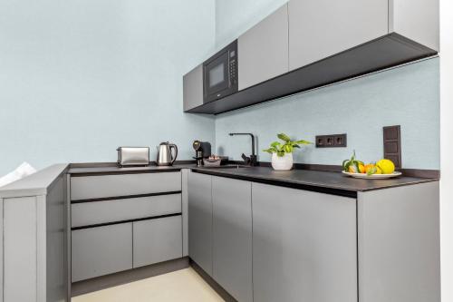 a kitchen with white cabinets and a black counter top at Nena Apartments München City East in Munich