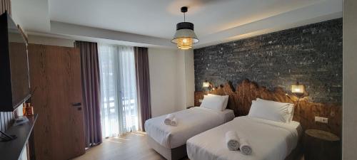 a hotel room with two beds and a brick wall at Hotel Ushba in Mestia in Mestia
