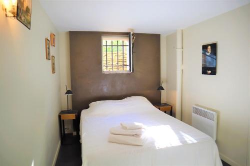 une chambre avec un lit blanc avec des serviettes dessus dans l'établissement Spacieuse Villa avec Piscine à La Cadière d'Azur - Villa Jenny, à Saint-Côme