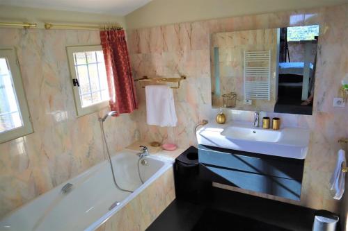 une salle de bain avec une baignoire et un lavabo et une baignoire dans l'établissement Spacieuse Villa avec Piscine à La Cadière d'Azur - Villa Jenny, à Saint-Côme