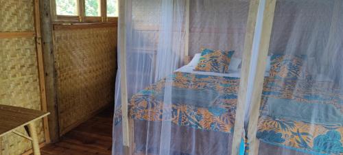 a bedroom with a bed with a canopy at Mwamba Kelele Lodge in Fort Portal