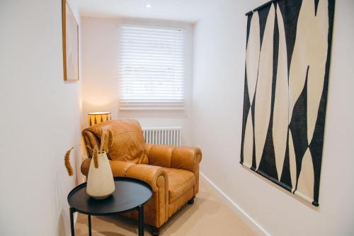 a living room with a brown leather chair and a table at Primrose House St. Ives in St Ives