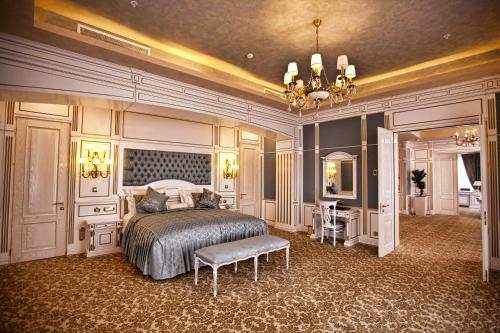 a large bedroom with a bed and a chandelier at Multi Grand Pharaon Hotel in Yerevan