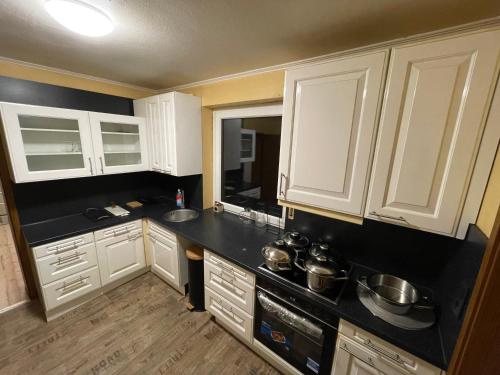 a kitchen with white cabinets and a black counter top at Sleep Point Bremermann in Bremen