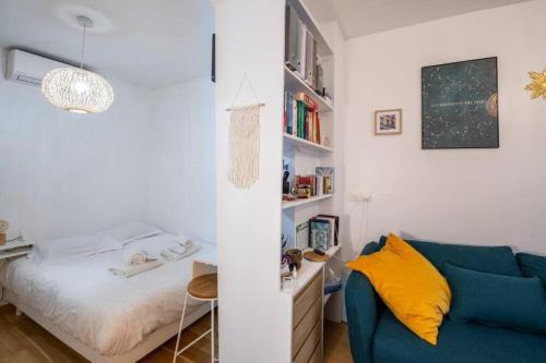 - un salon avec un canapé bleu et un lit dans l'établissement Appartement cosy avec terrasse, à Paris