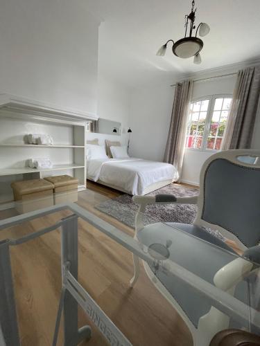 ポンタ・ド・ソルにあるCasa Cabozのベッドルーム1室(ベッド1台、ガラス張りのテーブル付)