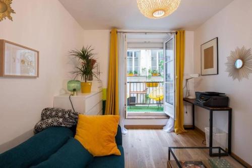 un salon avec un canapé bleu et une fenêtre dans l'établissement Appartement cosy avec terrasse, à Paris