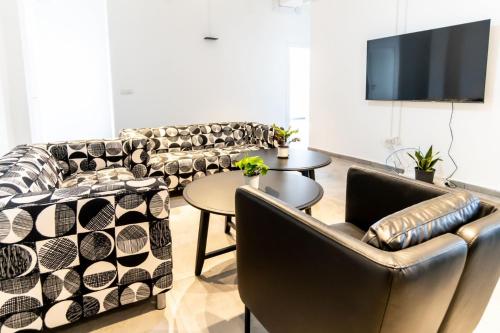 a living room with couches and a table and a tv at Apartment 34 in Derech Jaffa in Tel Aviv