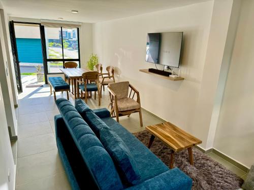 un soggiorno con divano blu e tavolo di Casa Turística en el Quindío a La Tebaida