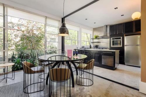 a kitchen with a glass table and chairs and a kitchen withuclear at Authentic 1BR in Polanco in Mexico City