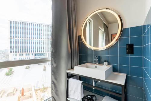 uma casa de banho com um lavatório e um espelho em JOST Auberge de Jeunesse Lille Centre em Lille
