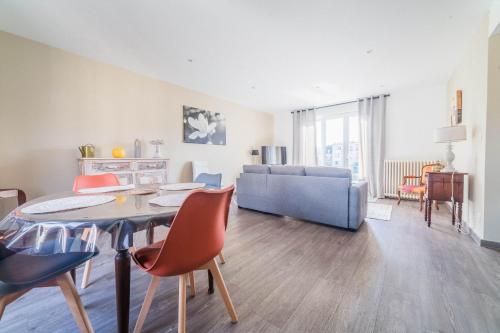 un salon avec une table, des chaises et un canapé dans l'établissement Le Balcon - 2 Chambres, à Brive-la-Gaillarde