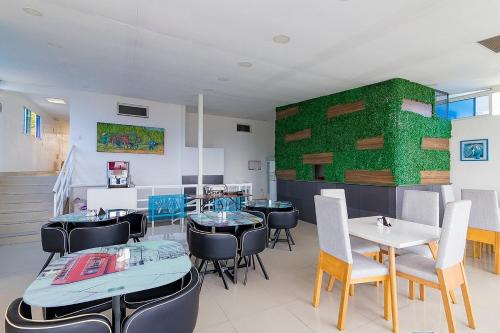 ein Restaurant mit Tischen und Stühlen und einer grünen Wand in der Unterkunft CHIPICHAPE INN in Cali