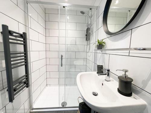 y baño blanco con lavabo y ducha. en The Beehive Newquay, en Newquay