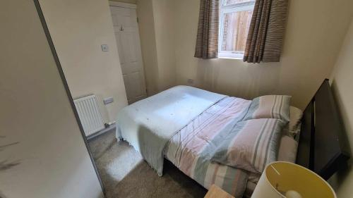Dormitorio pequeño con cama y espejo en 'The Potting Shed' en Knaresborough