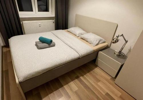 - un lit avec un oreiller et une lampe dans l'établissement Poznań park, à Poznań