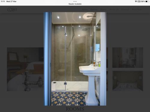 uma casa de banho com um chuveiro e um lavatório branco em Coast Guest House em Whitby