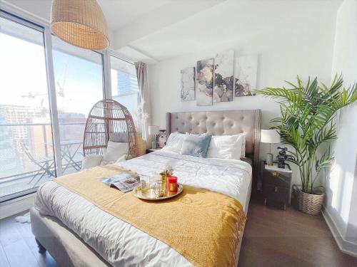 Un dormitorio con una cama con una bandeja de comida. en INFIVILLA Deluxe Suites in Downtown Toronto with Amazing View en Toronto
