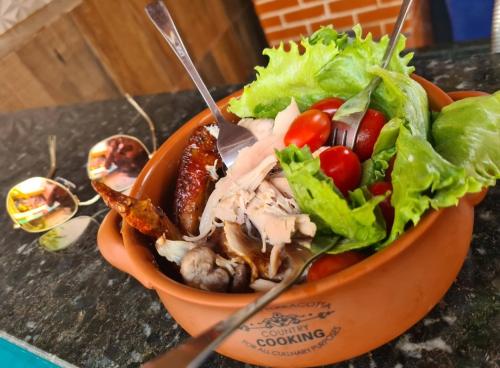 Salat in einer orangenen Schale auf einer Theke in der Unterkunft Casa mobiliada para periodo da tecnoshow 3 quartos sendo uma suíte sala copa cozinha área de lazer com piscina e bar molhado com churrasqueira 4 banheiros cozinha montada na área de lazer com 2 churrasqueiras elétrica e comum in Rio Verde
