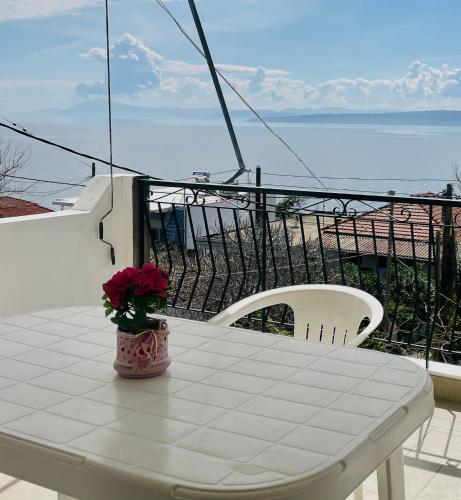 a white table with a vase of flowers on a balcony at Tasos Manaritsas Rooms in Khronia